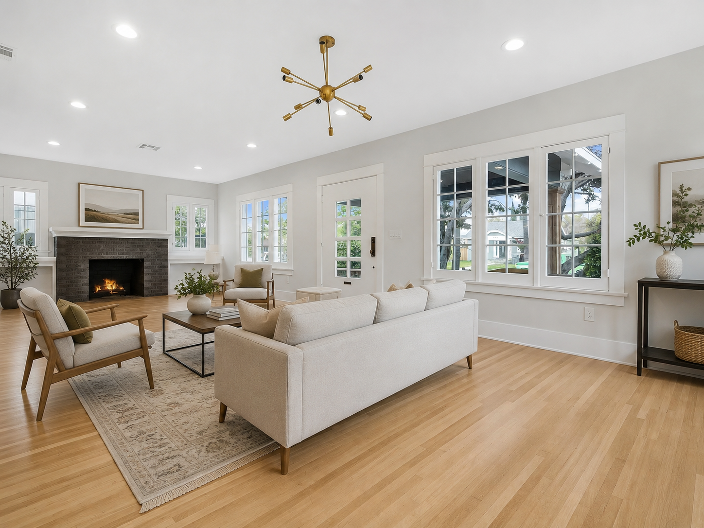 The Ross Home living room with a fireplace, bright windows, and warm wood floors