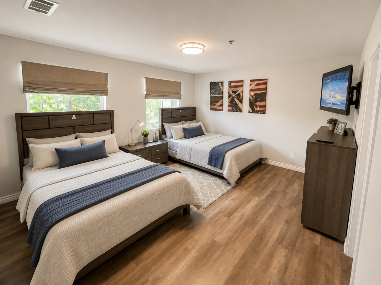 A shared bedroom with two queen beds and patriotic aviation artwork