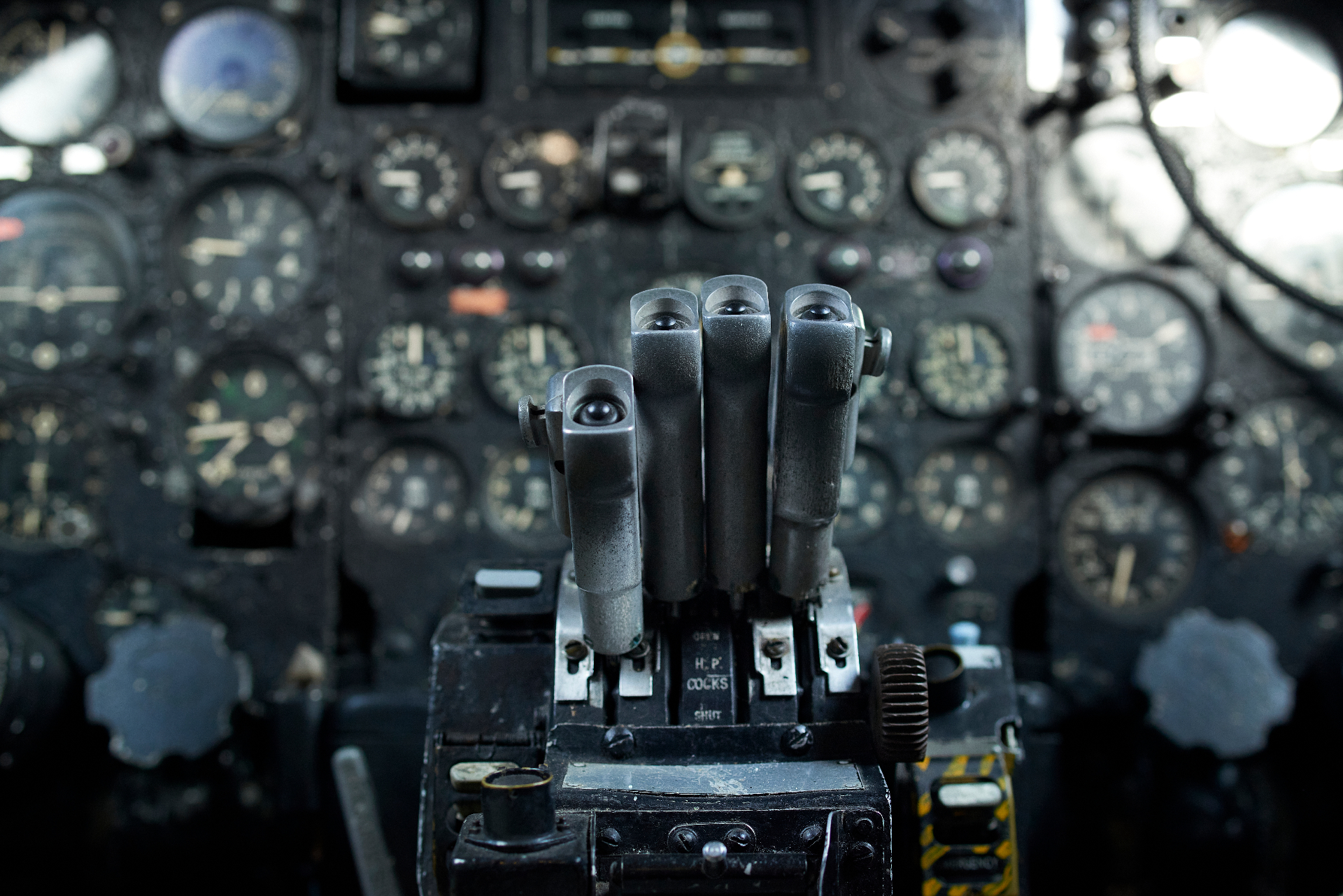 Detailed close-up of a vintage aircraft cockpit's throttle quadrant and instrument dials
