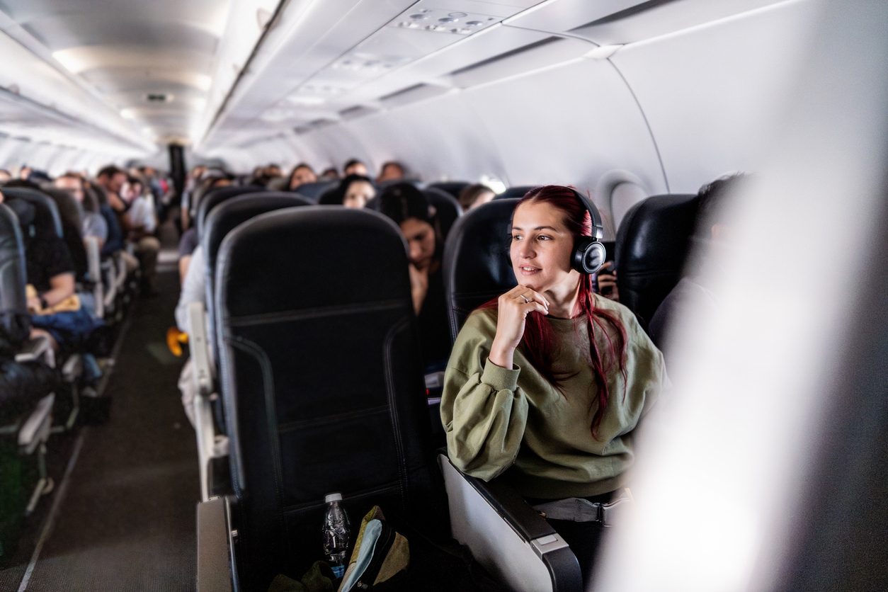 Passenger seated in an airplane cabin, calm and ready for arrival