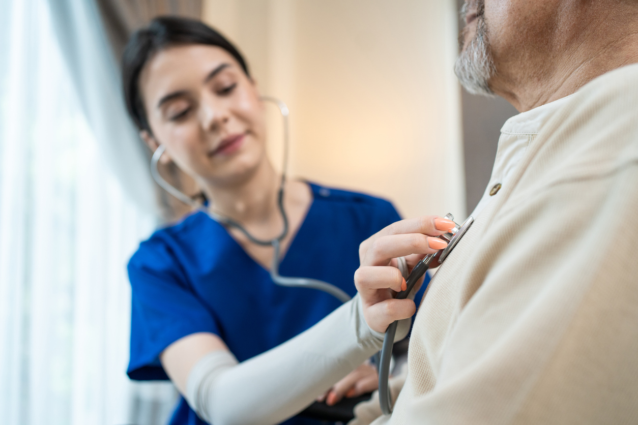 A clinician checking on a resting patient in a warm, homelike room